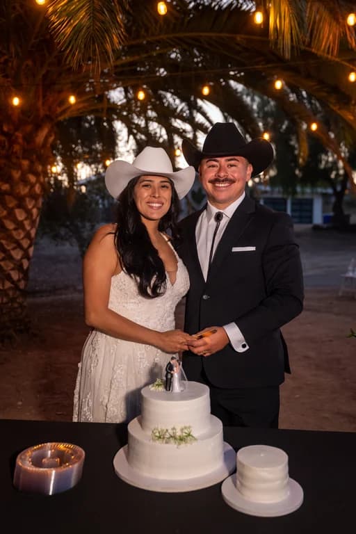 Josh + Julissa cutting the cake under string lights