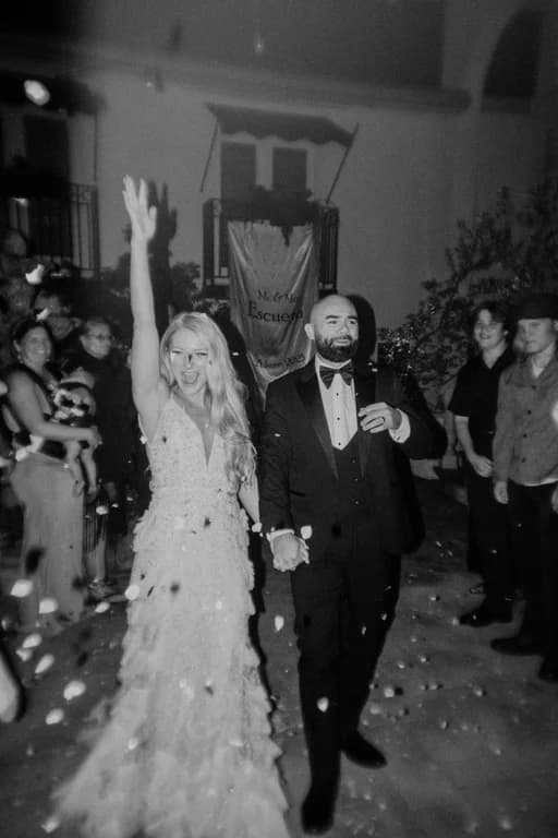 Jovin + Jordyn walking through confetti, in black and white
