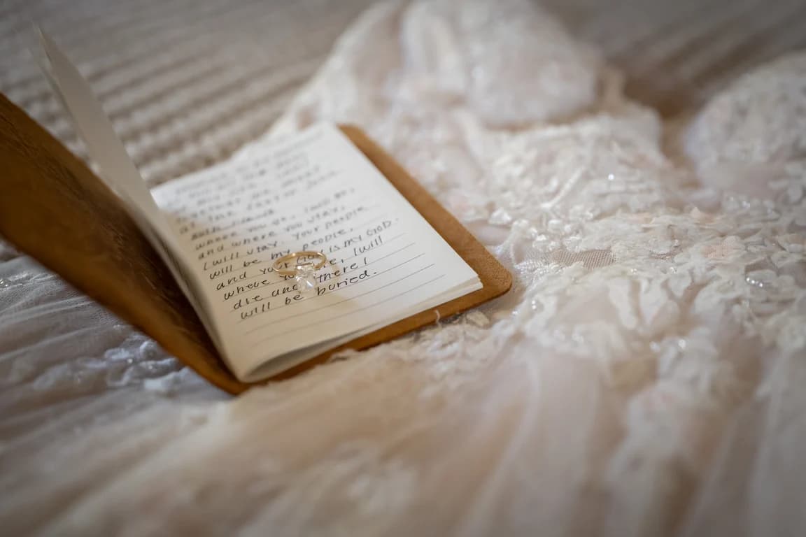 Handwritten vows resting on the lace of the dress