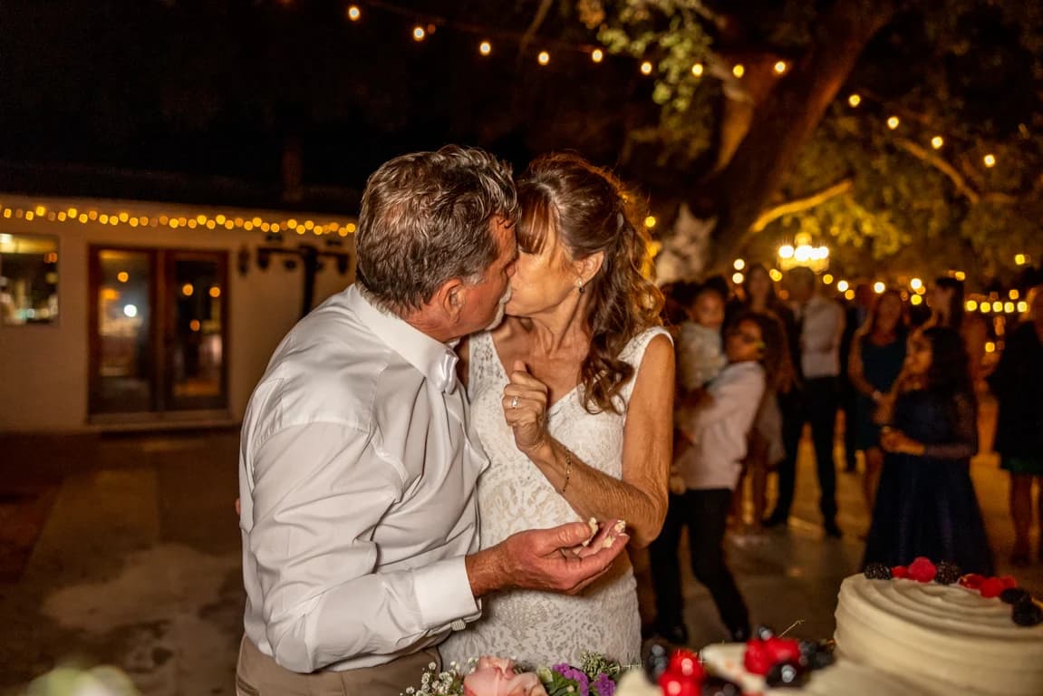 Randy + Joy kissing under string lights