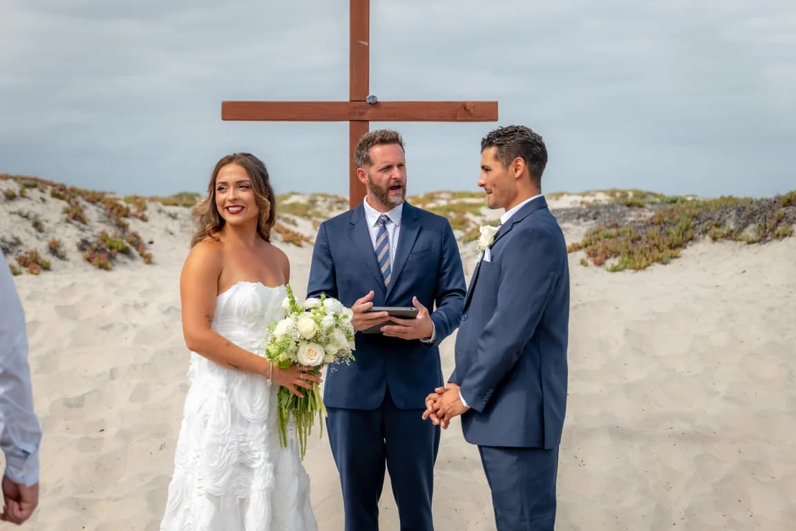 Kiara and Niko with the officiant at the cross
