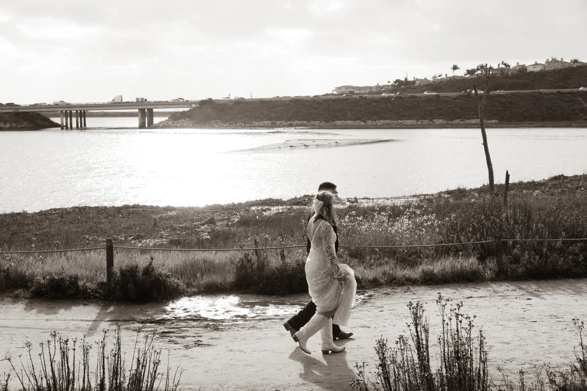 Corbin + Michaela walking along the lagoon, in black and white