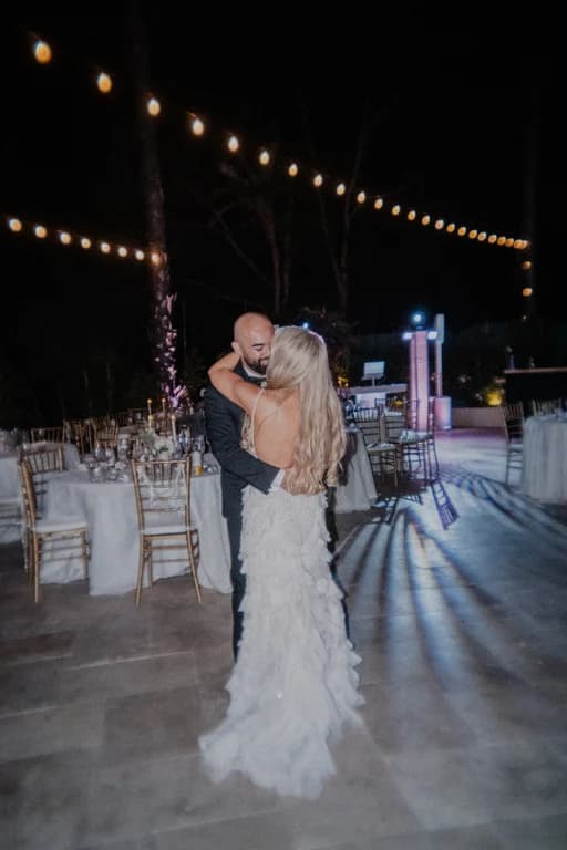 Jovin + Jordyn dancing under string lights and purple uplights