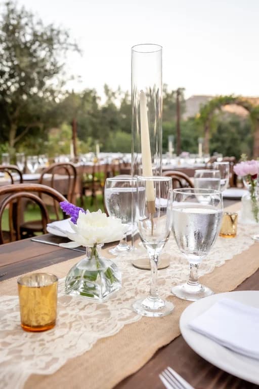 A dinner table set with candles and glassware