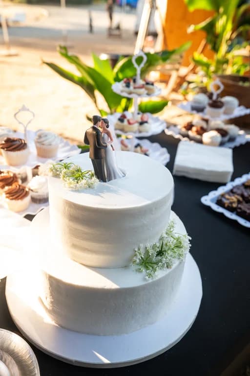 The wedding cake with a couple topper, and desserts