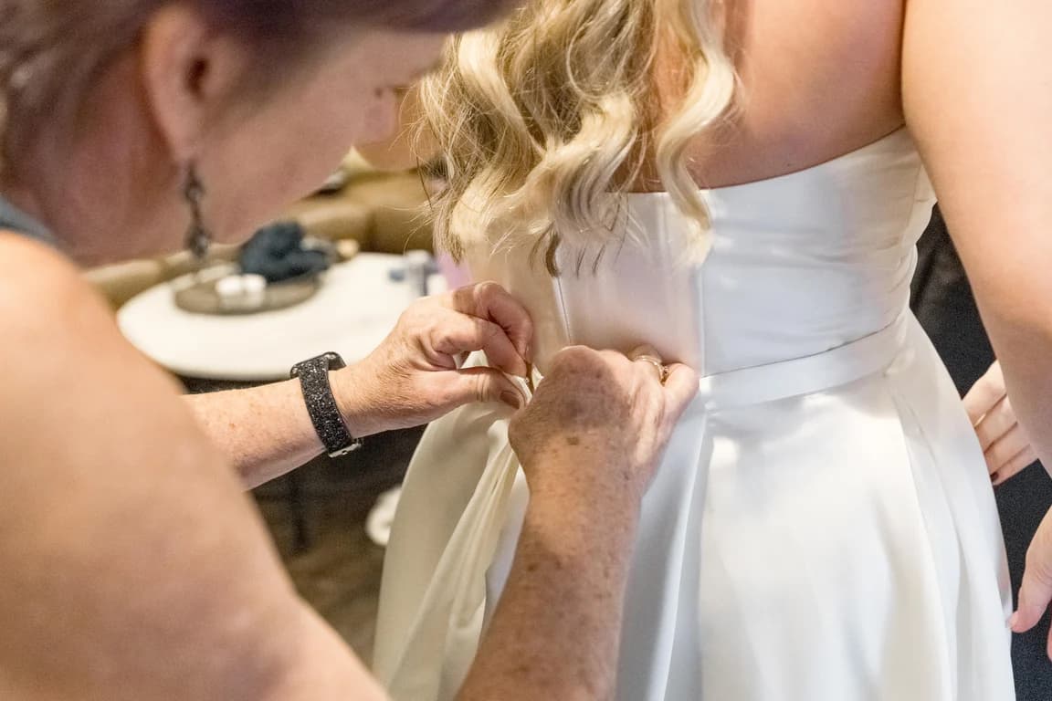 Buttoning the back of Cecelia's dress