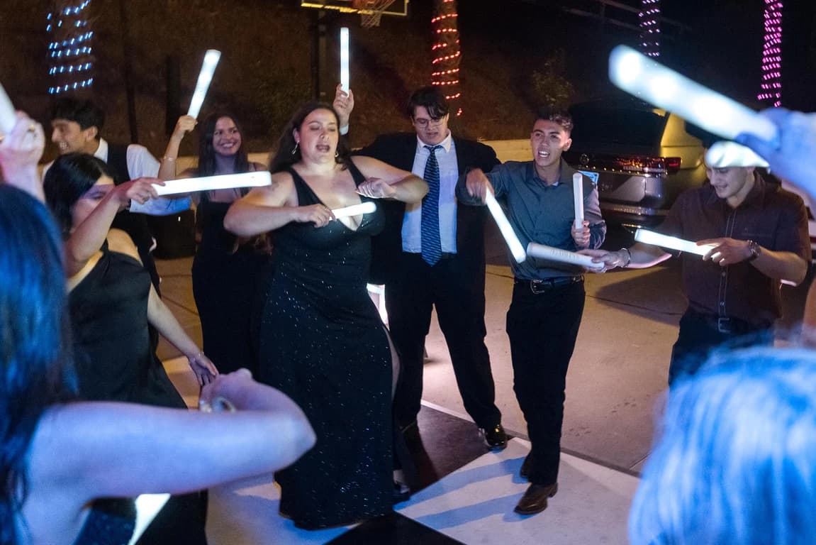Joseph + Cecelia dancing with glow sticks under colored lights