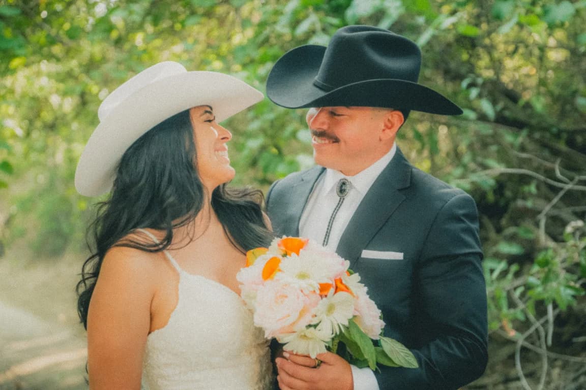 Julissa in a white hat laughing with Josh