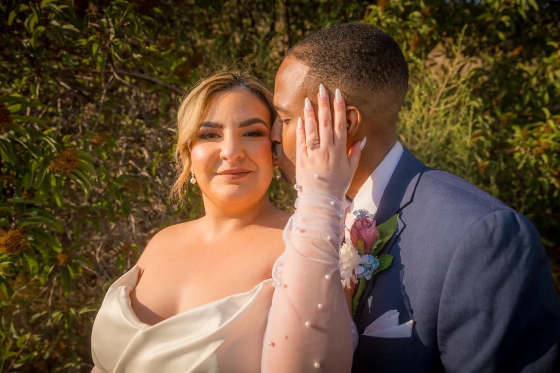 Lola resting her cheek against Brandon's, her ring in view