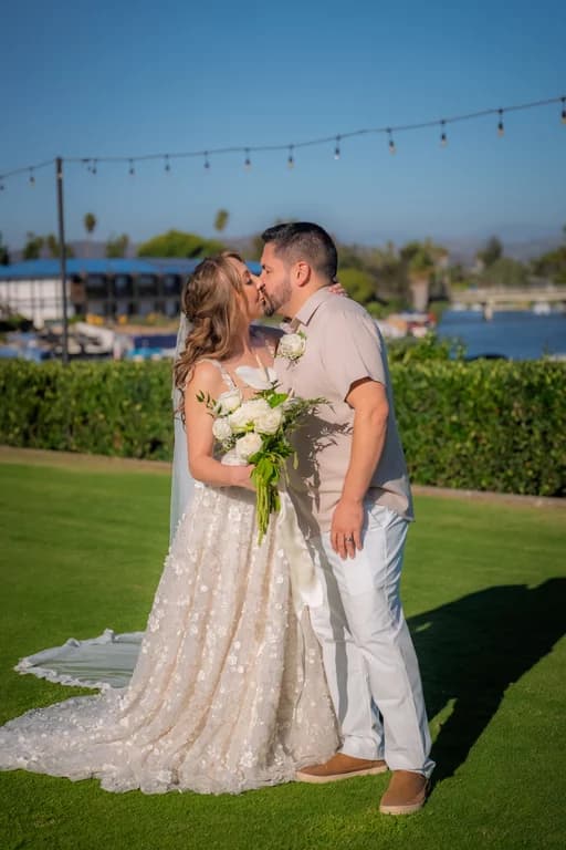 Katy + Ryan smiling on the lawn under string lights