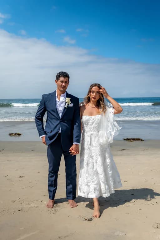 Niko + Kiara on the beach, the waves behind them