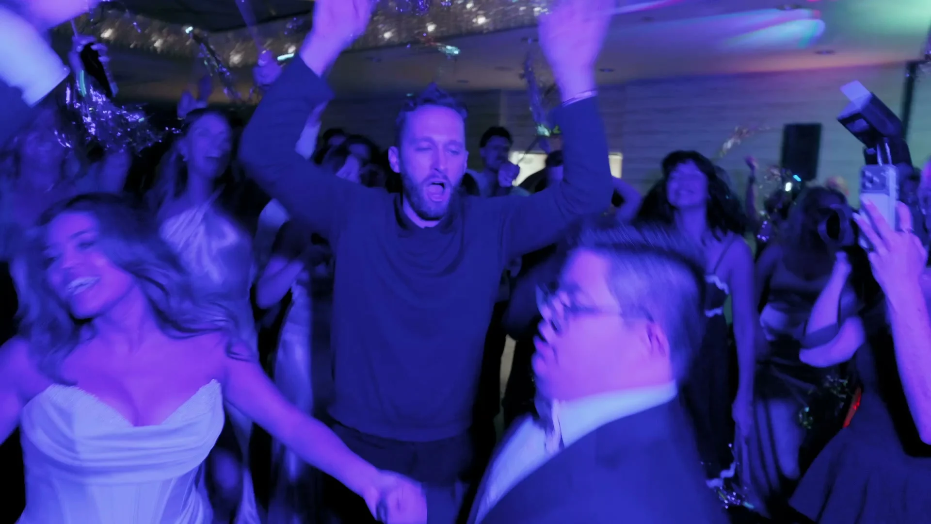 A packed dance floor in purple light