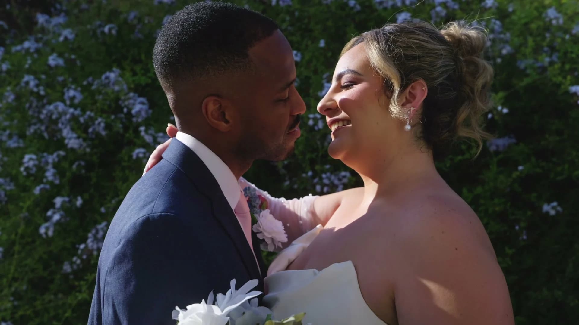 Brandon + Lola close together against the hedge of purple blooms