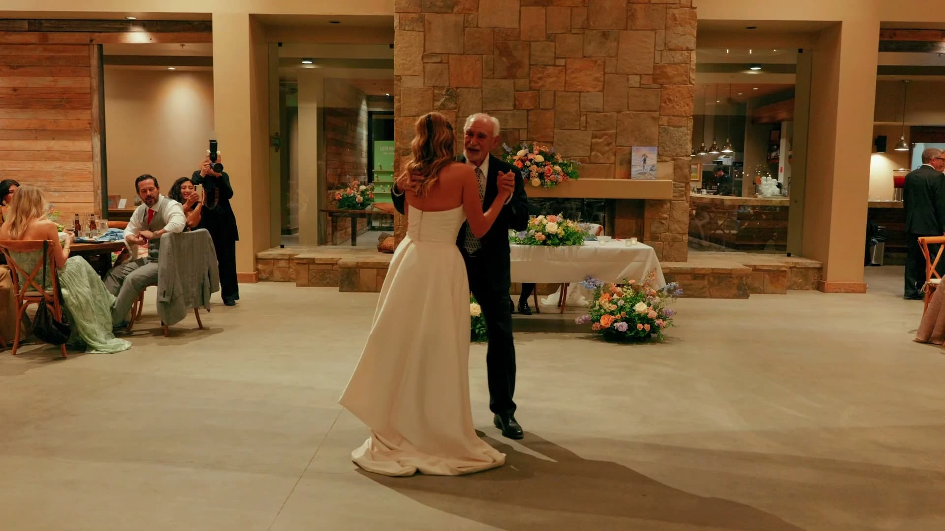 A dance by the stone fireplace at the reception