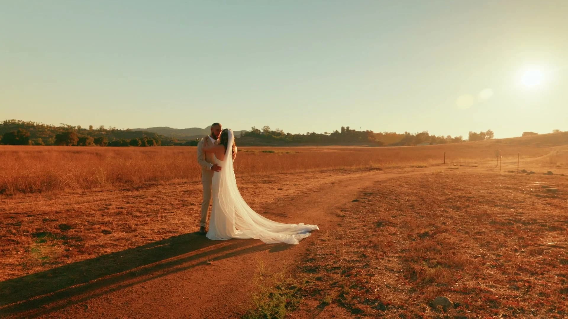 Ivan + Yesenia far out in the field as the sun sets