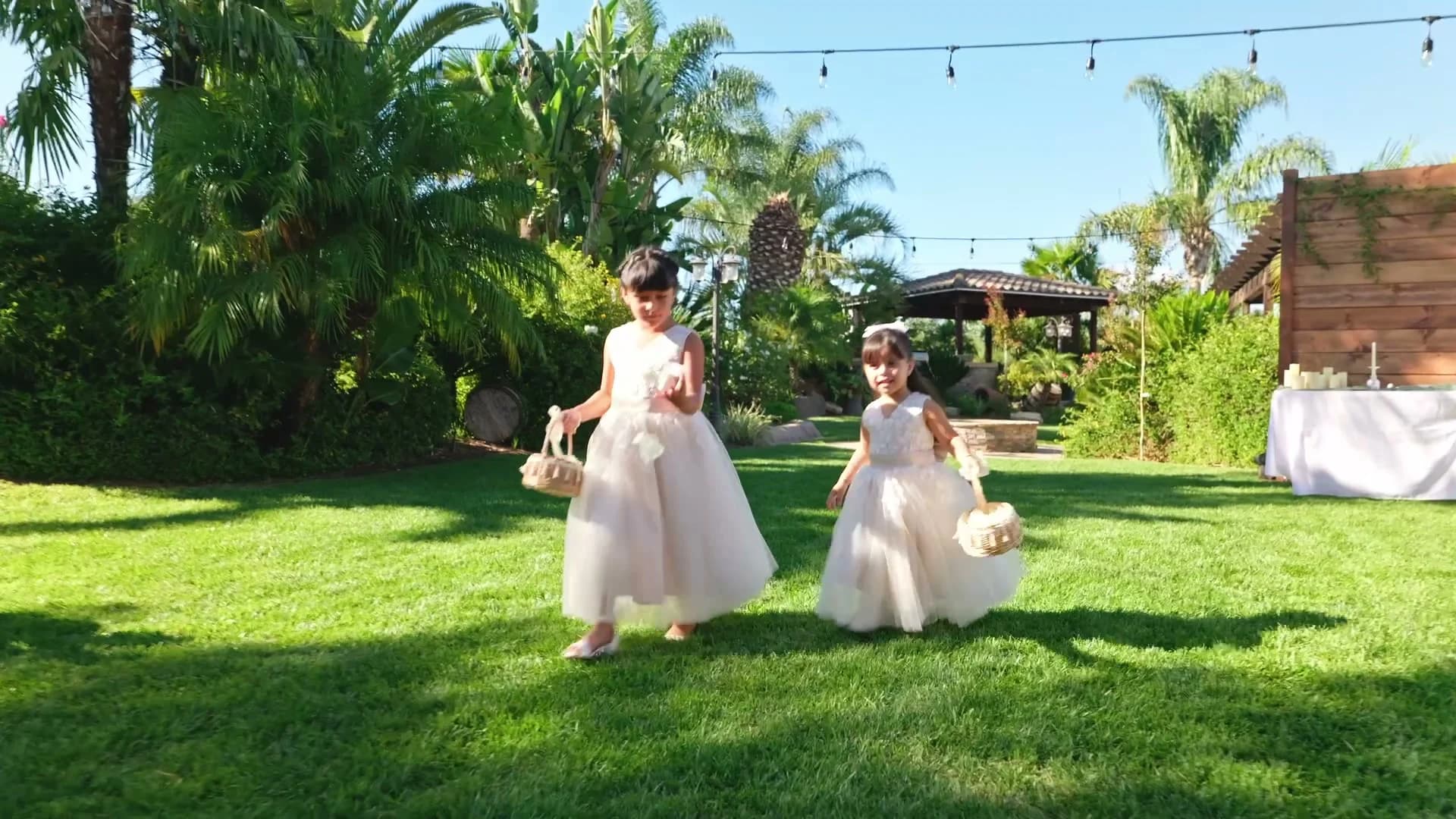 Two flower girls walking down the aisle on the lawn
