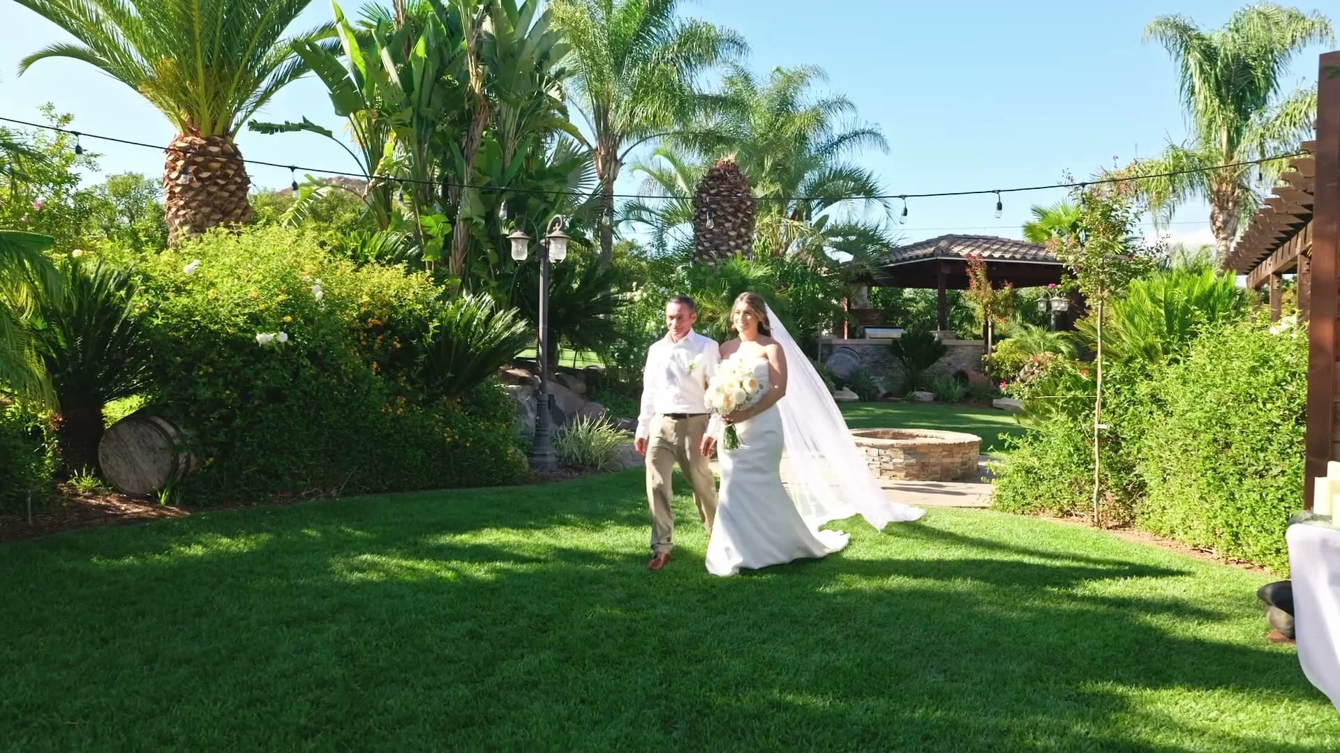 Yesenia walking down the aisle under the string lights