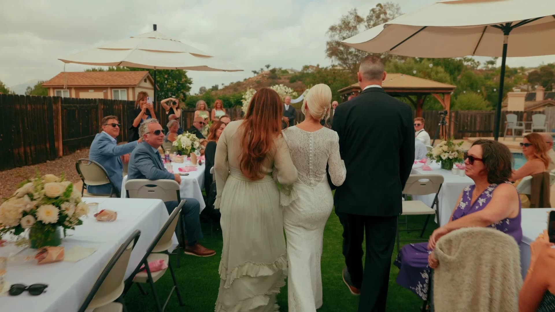 Luana walking down the aisle between the tables