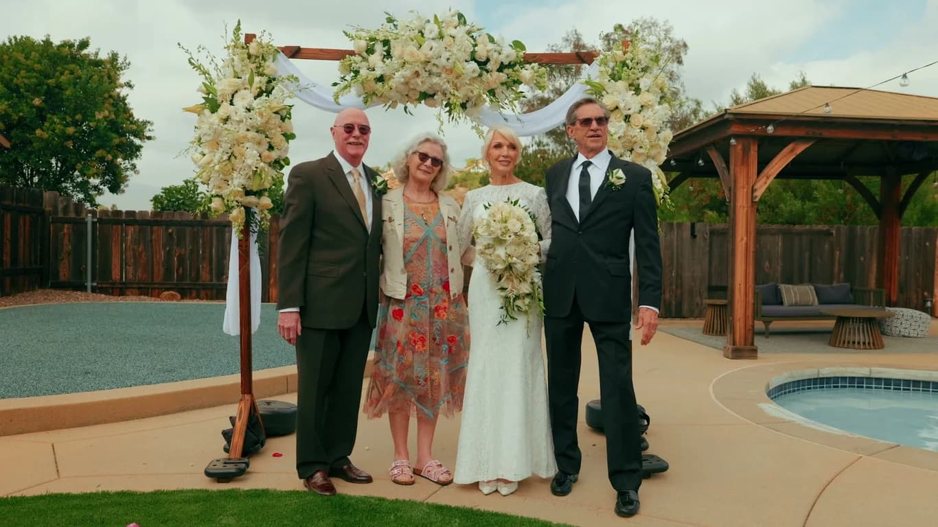 Luana + Charles with family by the floral arch