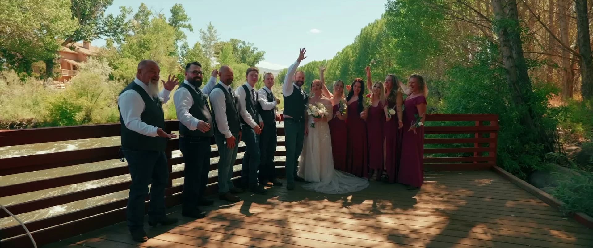 The wedding party cheering on the red deck above the river