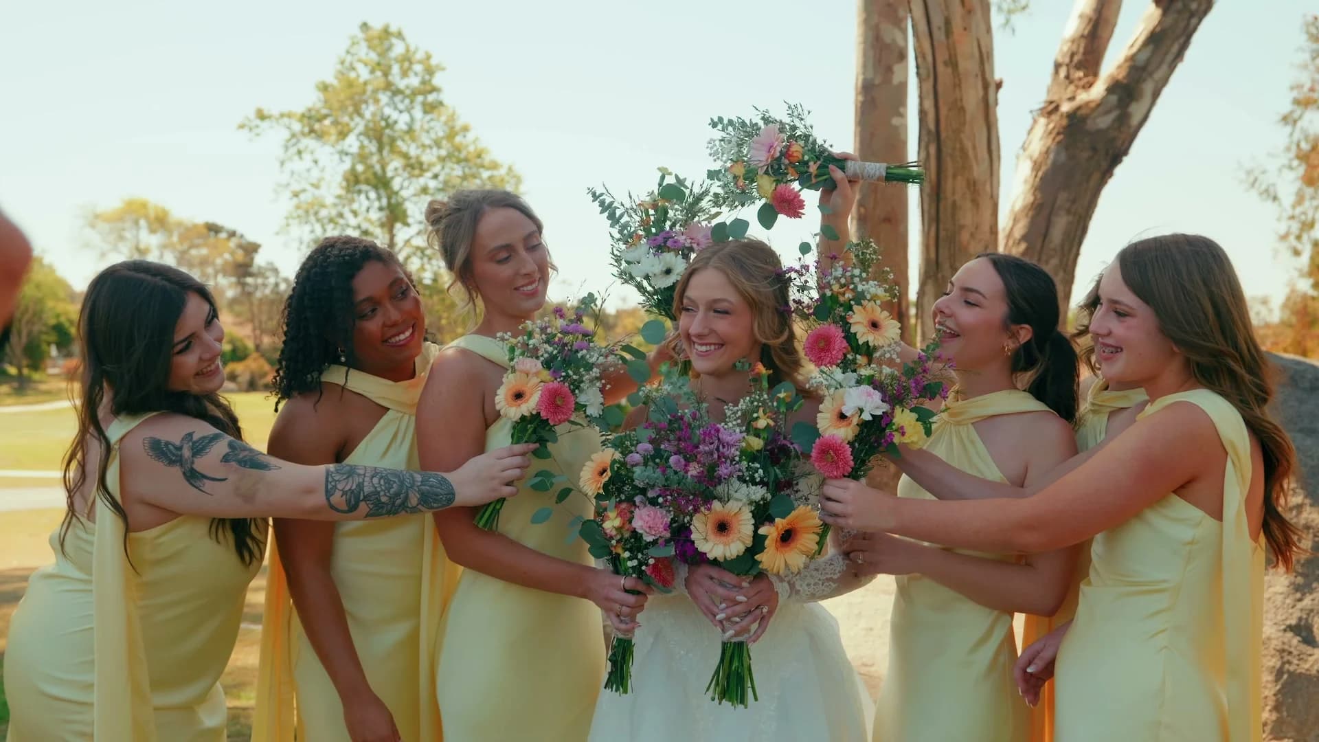 Kat with her bridesmaids in buttery yellow, her bouquet of bright flowers