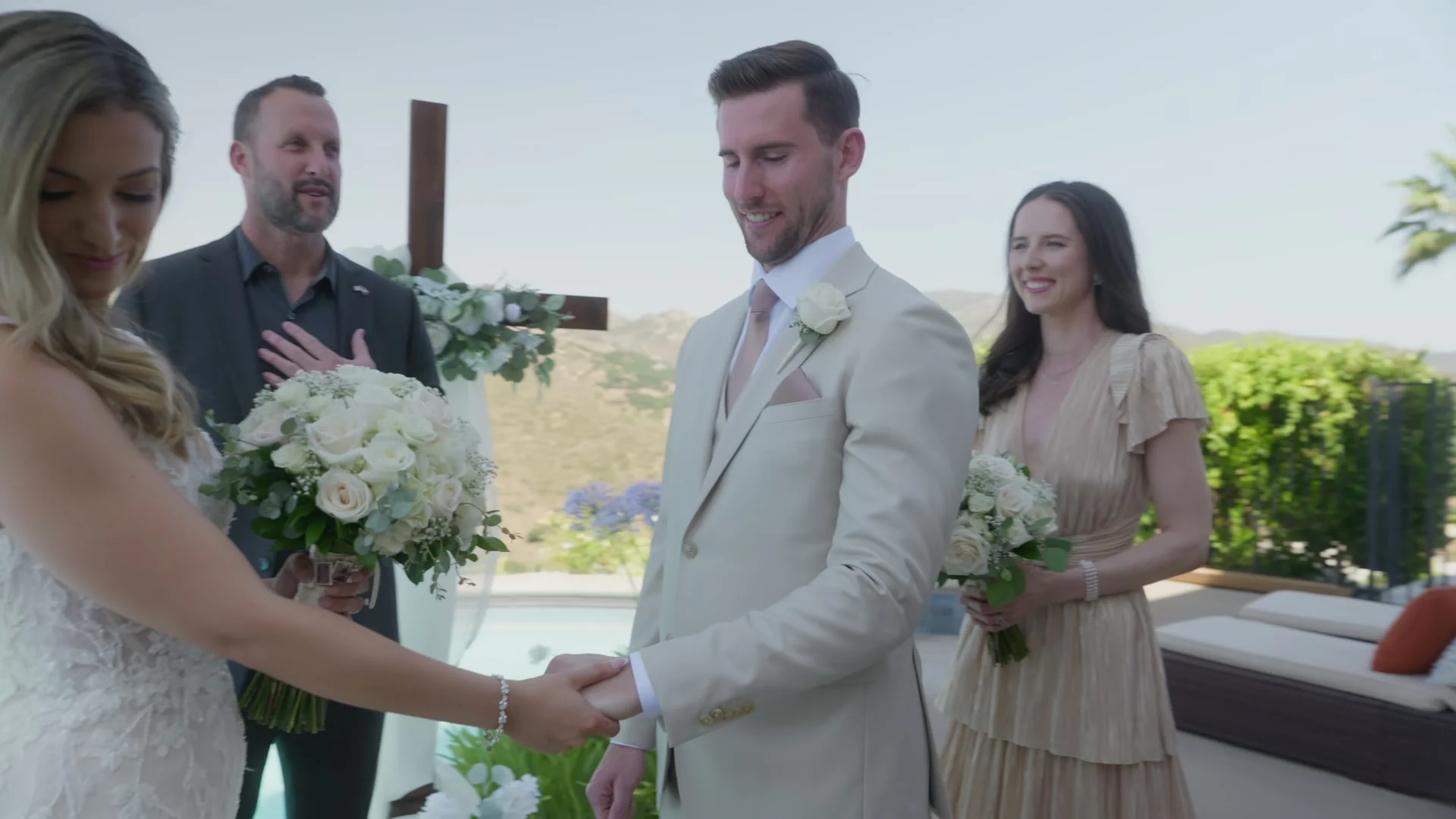 Patrick + Megan with the officiant and a bridesmaid by the wooden cross