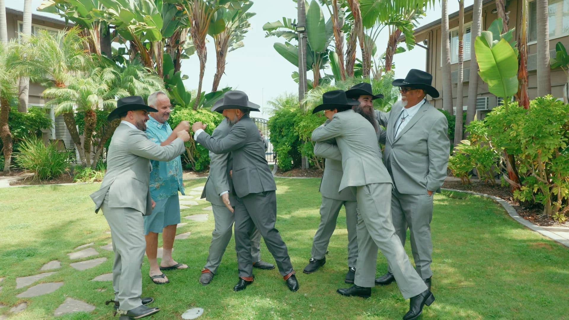 The groomsmen celebrating together on the lawn