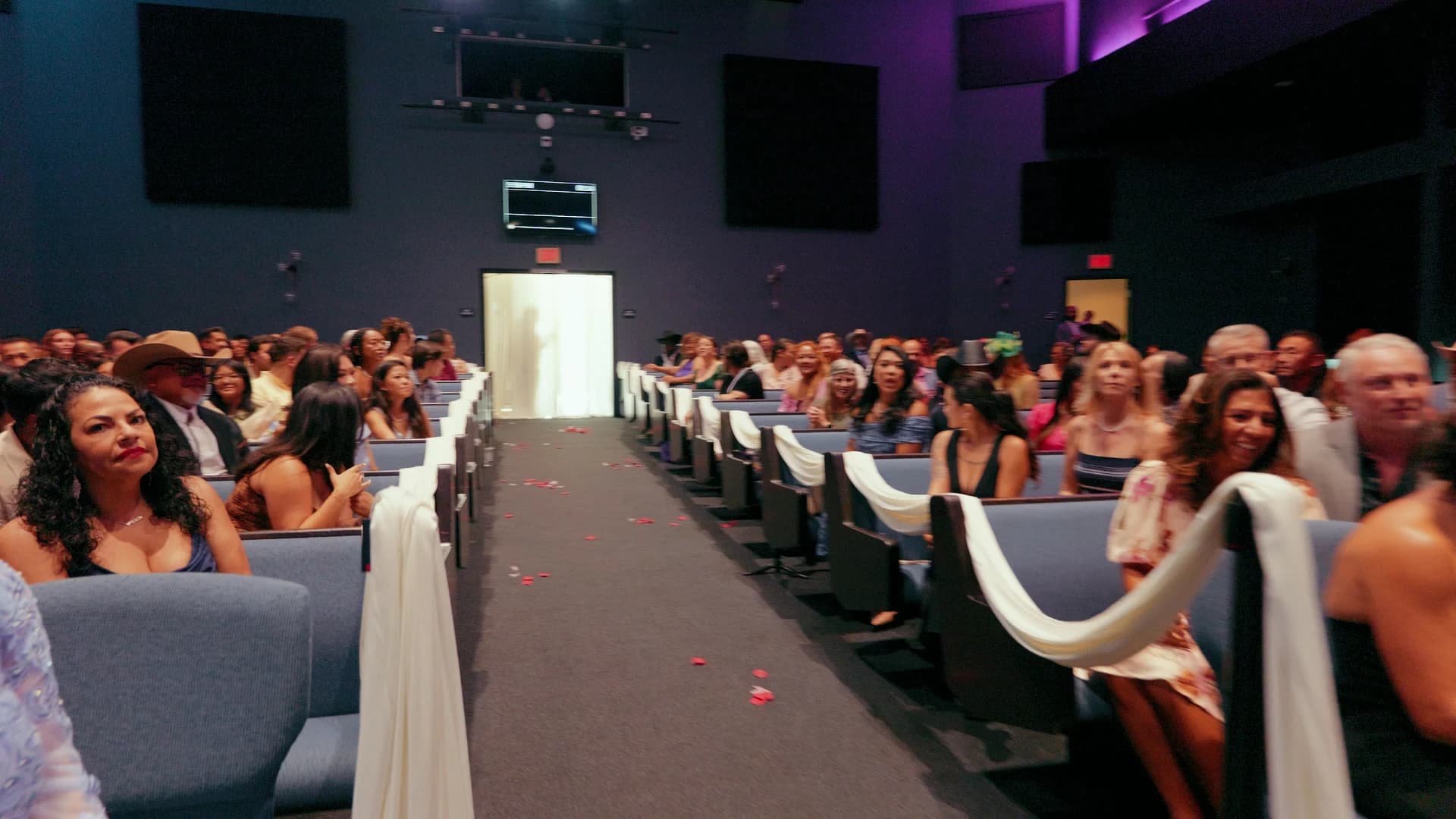 Guests filling the sanctuary at Awaken Church, the aisle lined in white