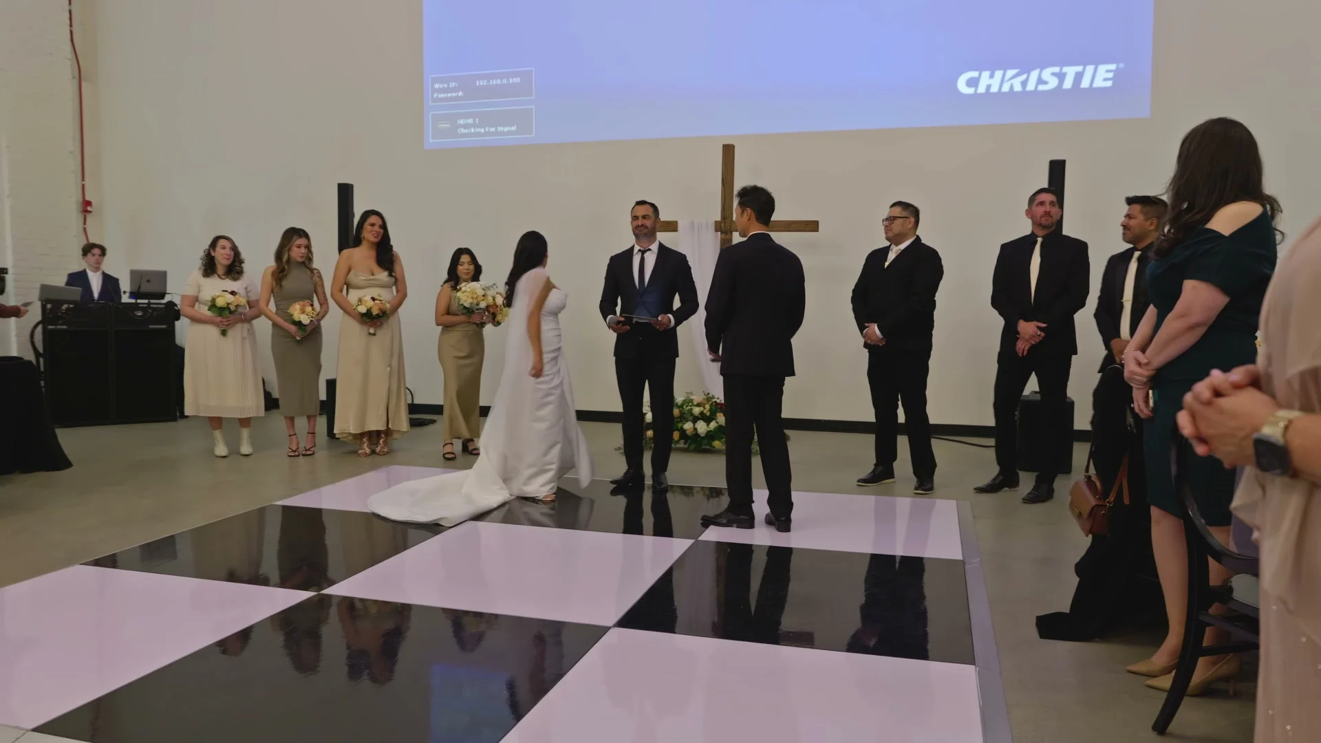 The ceremony under a large wooden cross, the wedding party on either side