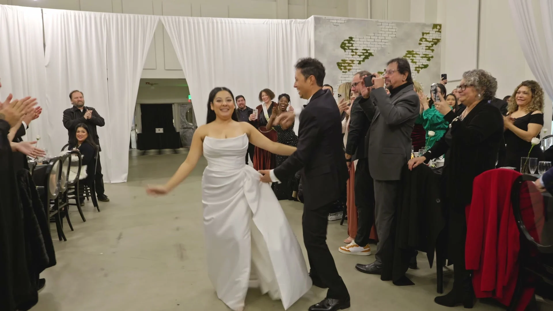 Sabrina dancing as the newlyweds come in, guests clapping