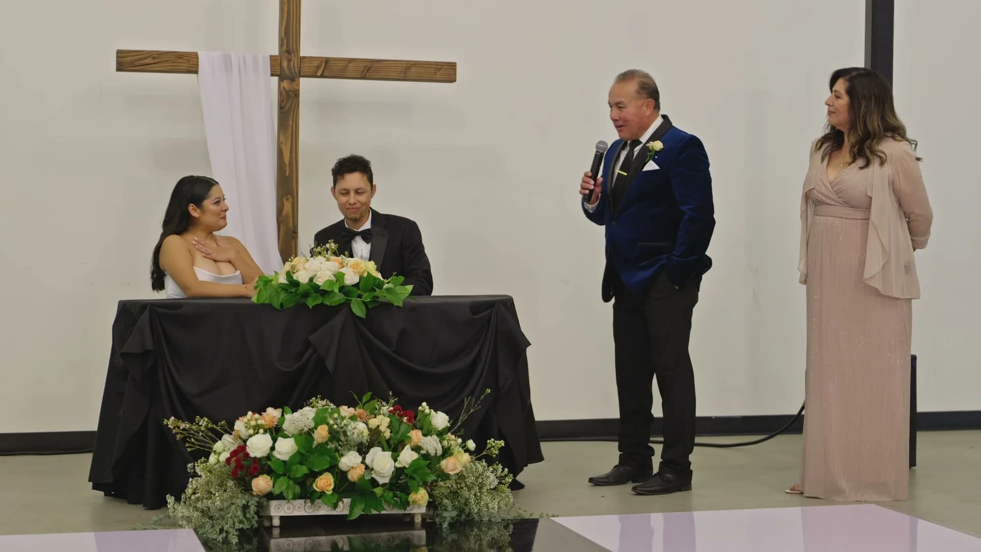 Sabrina + Caleb at the signing table beneath the cross