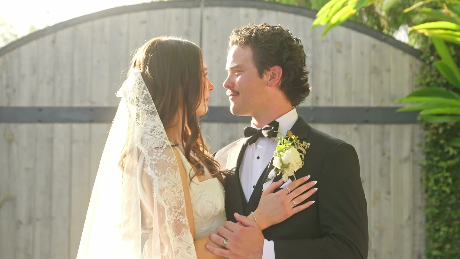 Zach + Madelin in golden light at the wooden gate
