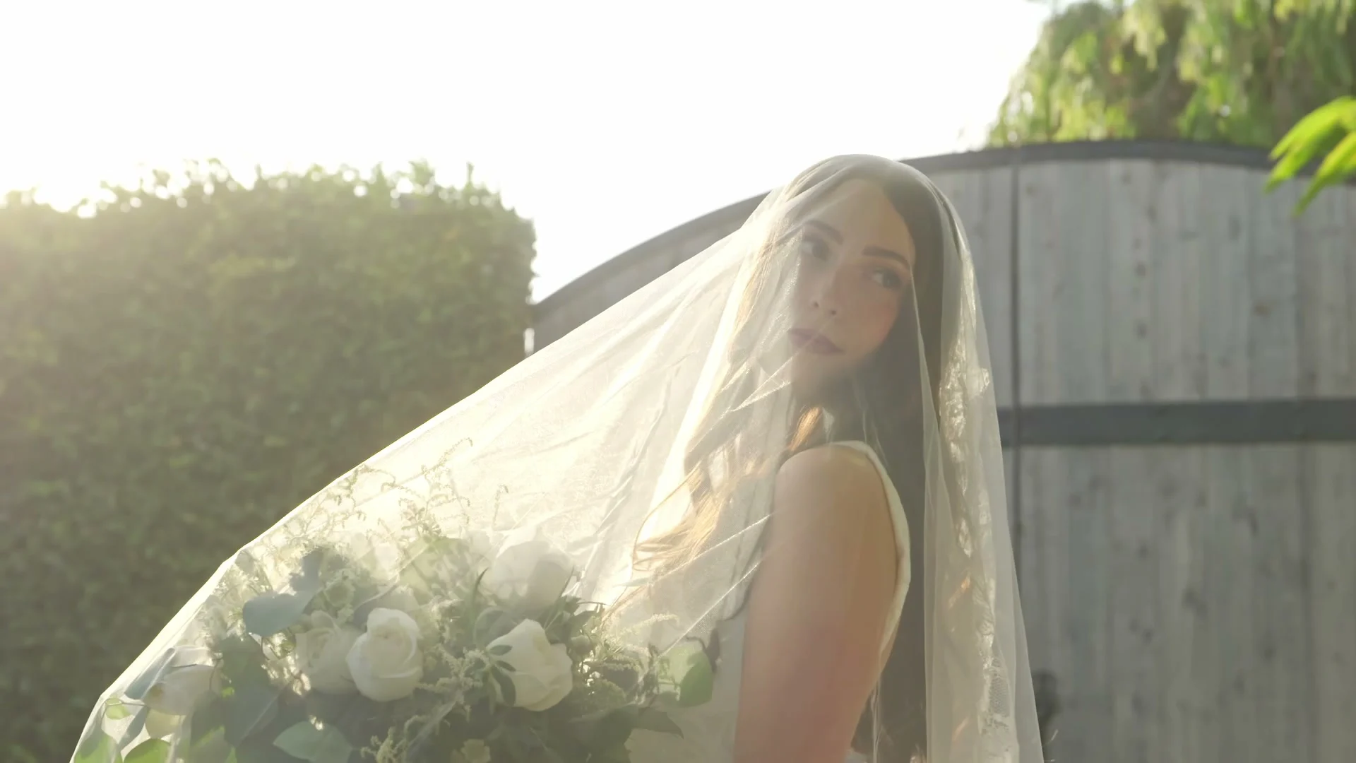 Madelin's veil backlit by the sun at the garden gate