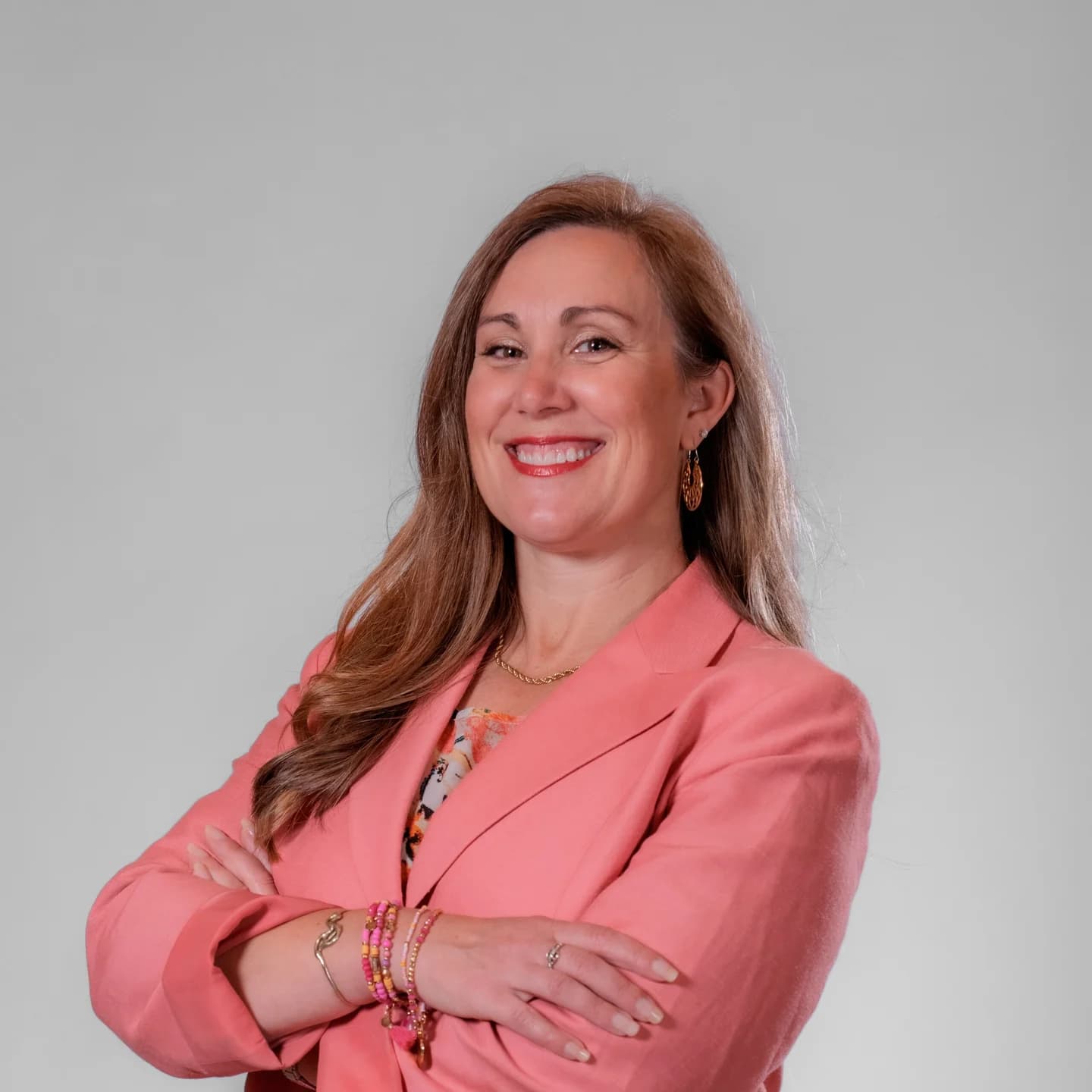 Studio headshot of a conference attendee in a pink blazer, taken at the on-site headshot station at Adored Wife Weekend, San Diego